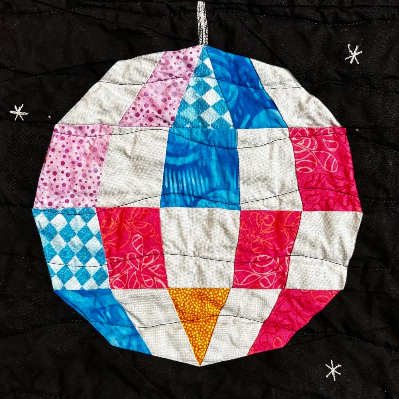 Quilted disco ball block in pink, blue, and white prints